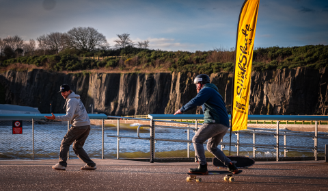 A surf skate class taking place with a coach leading a student