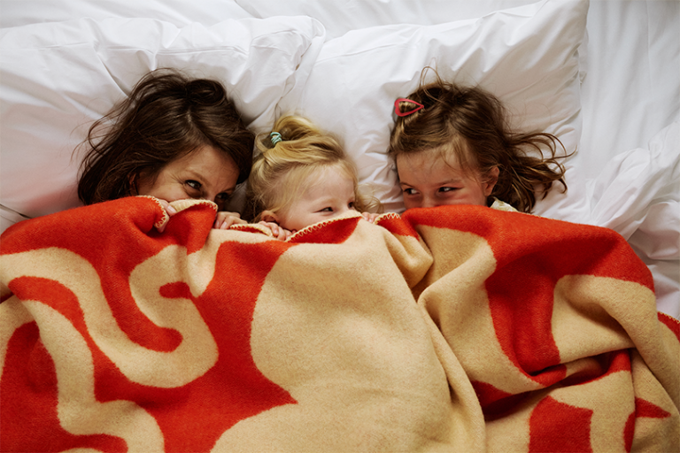 Three children under a blanket
